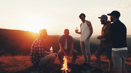 Men camping and drinking beer around a fire