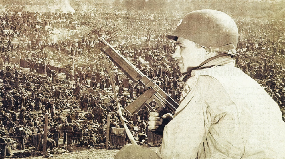 An American soldier at Camp Remagen, one of the Rheinwiesenlager camps, guarding thousands of German soldiers captured in the Ruhr area, April 1945.